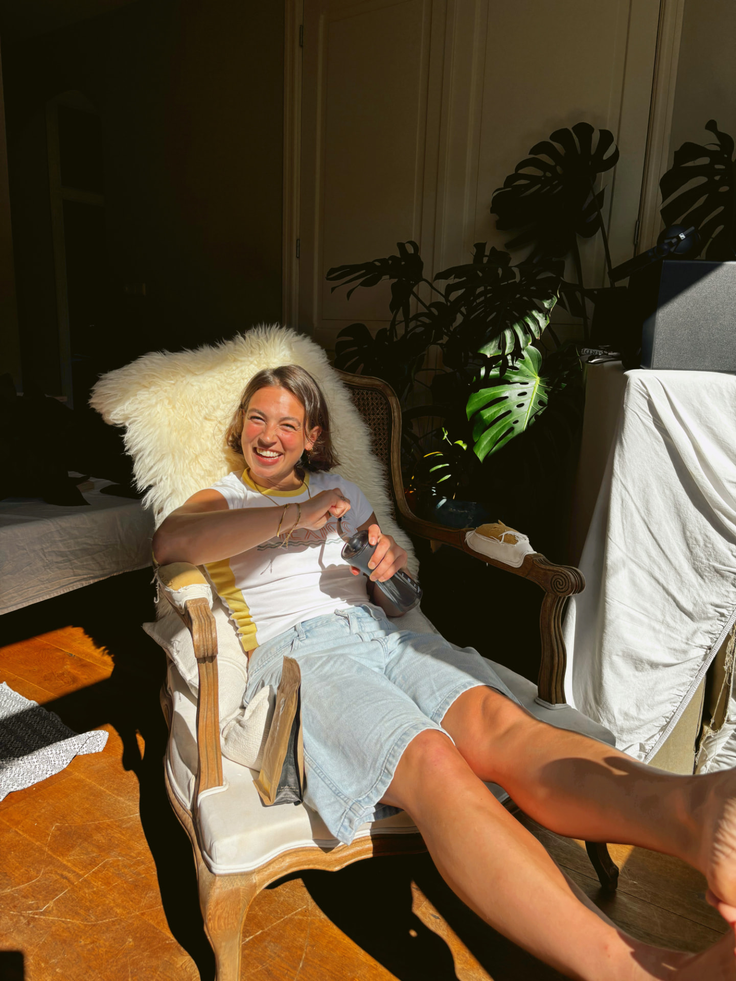 Julia laughing in an armchair in the evening sun