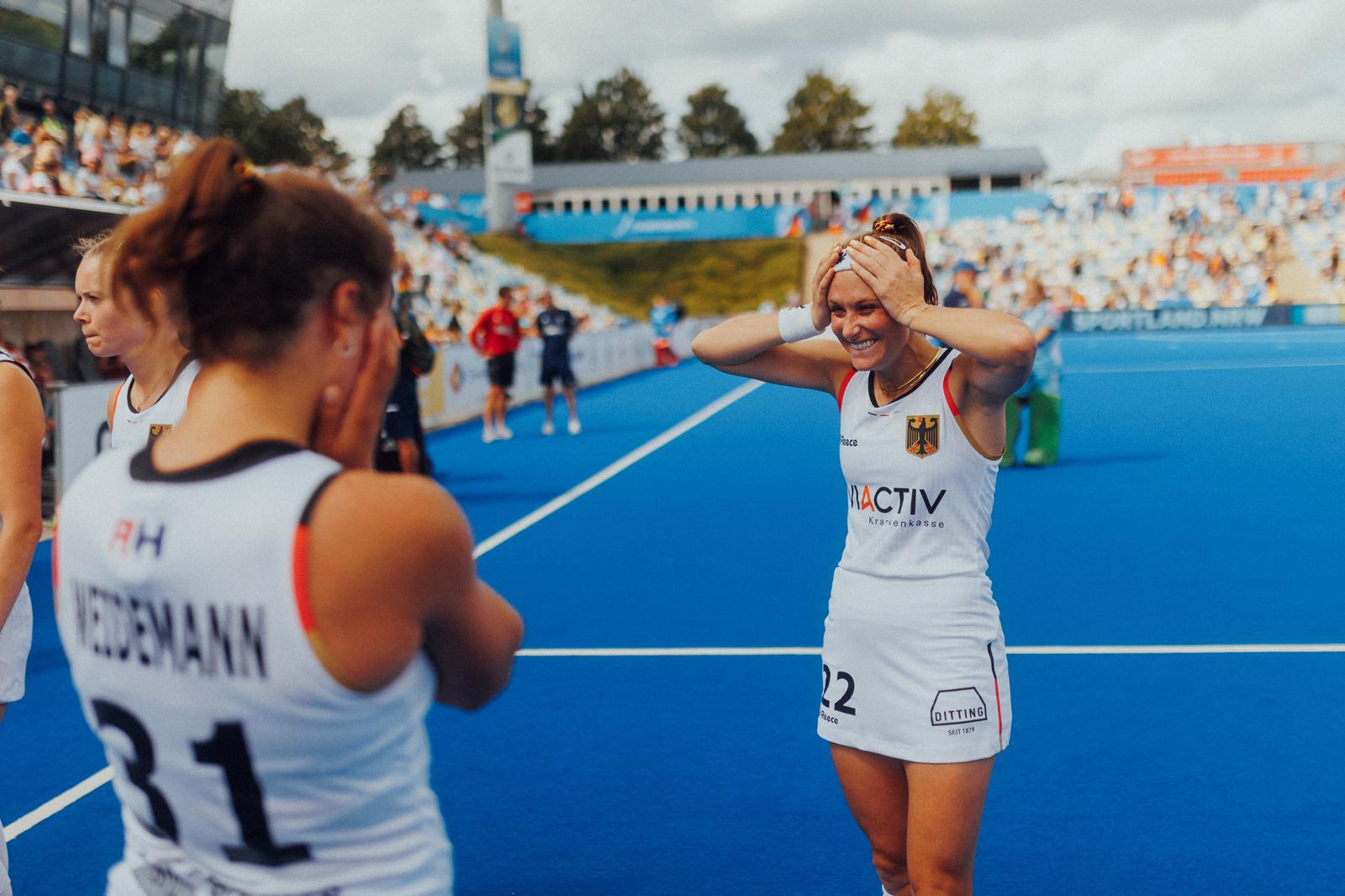 Cécile smiling with her hands on her head on the pitch